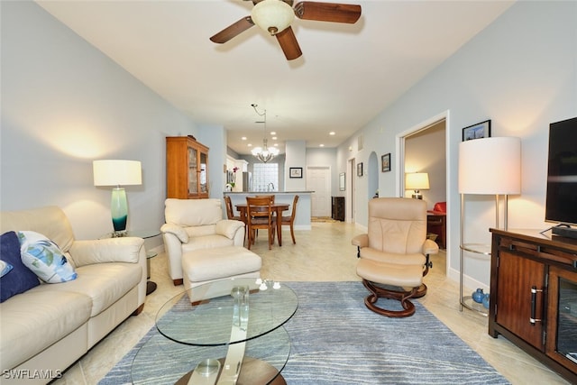 living room featuring baseboards and ceiling fan with notable chandelier