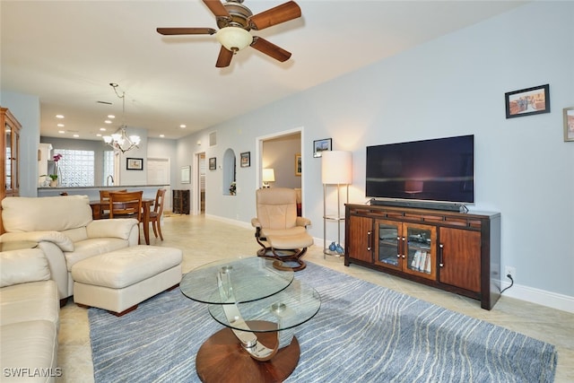 living area featuring ceiling fan with notable chandelier, recessed lighting, and baseboards