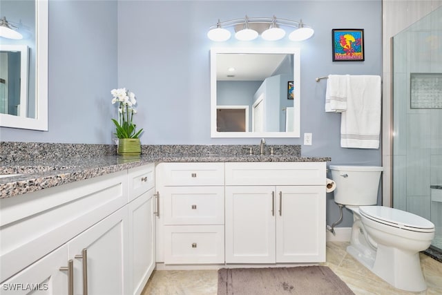 full bathroom featuring a shower with door, vanity, and toilet