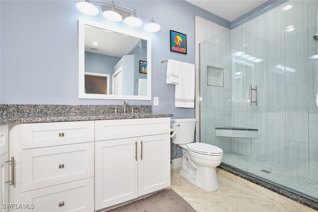 bathroom featuring toilet, a stall shower, and vanity