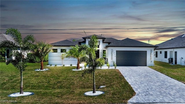 1316 SW 23rd St, Cape Coral, FL 33991 - view of front of home featuring a garage, stucco siding, decorative driveway, and a front yard