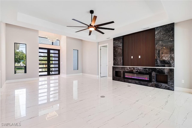 1316 SW 23rd St, Cape Coral, FL 33991 - unfurnished living room featuring a raised ceiling, baseboards, marble tiled floors, and a ceiling fan