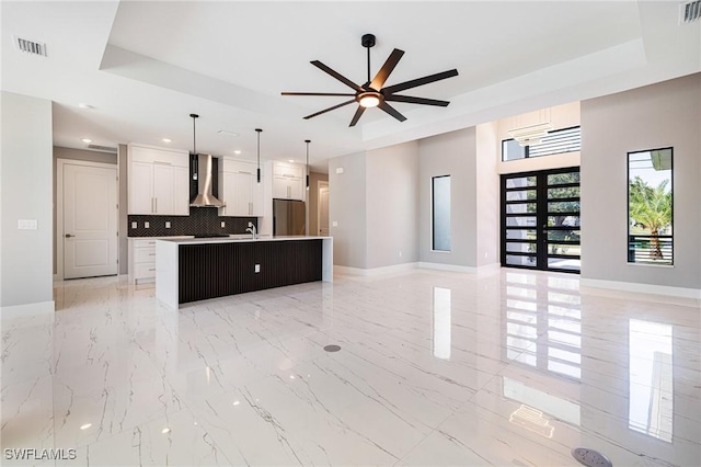 1316 SW 23rd St, Cape Coral, FL 33991 - kitchen featuring freestanding refrigerator, wall chimney range hood, a tray ceiling, open floor plan, and baseboards