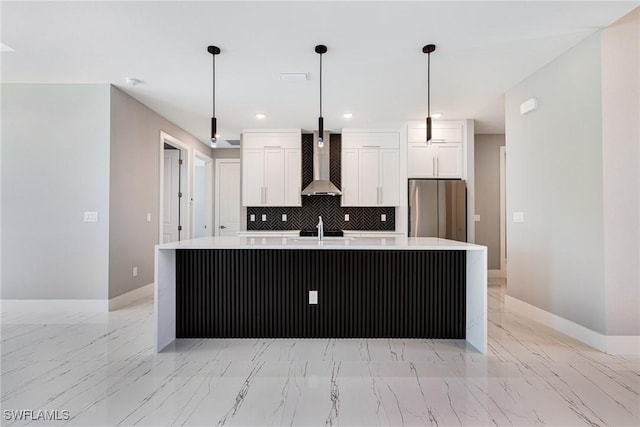 1316 SW 23rd St, Cape Coral, FL 33991 - kitchen with wall chimney exhaust hood, freestanding refrigerator, light marble finish flooring, white cabinetry, and backsplash