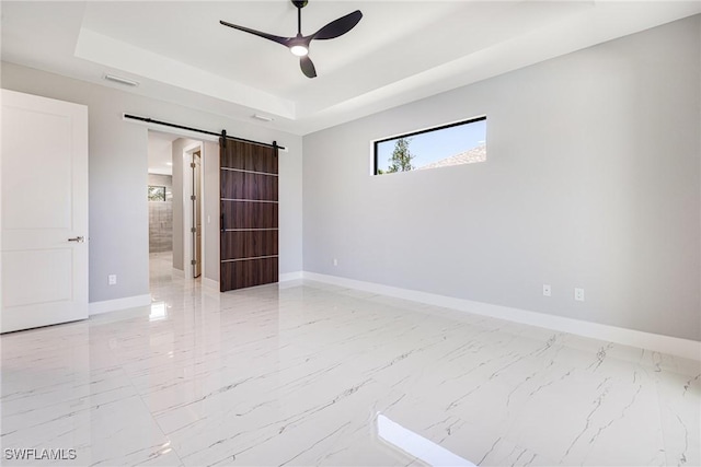 1316 SW 23rd St, Cape Coral, FL 33991 - spare room featuring a barn door, a raised ceiling, baseboards, and light marble finish floors