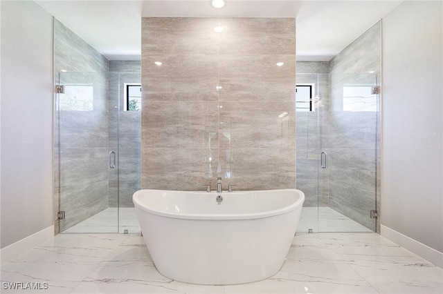 1316 SW 23rd St, Cape Coral, FL 33991 - bathroom with baseboards, marble finish flooring, a freestanding tub, and a shower stall