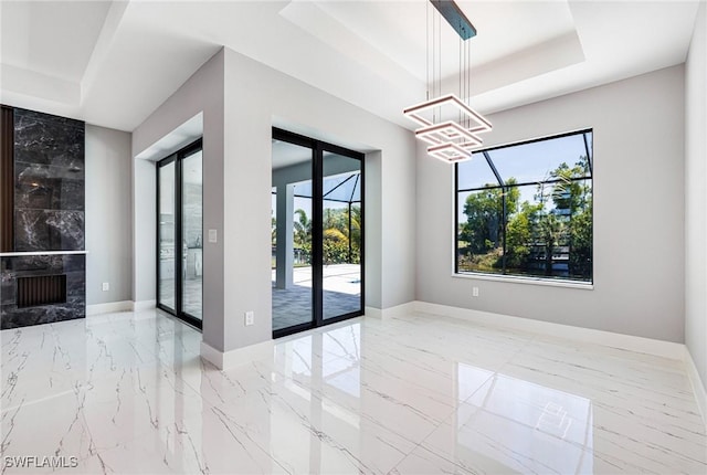 1316 SW 23rd St, Cape Coral, FL 33991 - empty room featuring a raised ceiling, plenty of natural light, and a chandelier