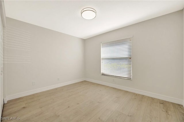 spare room featuring light wood-type flooring and baseboards