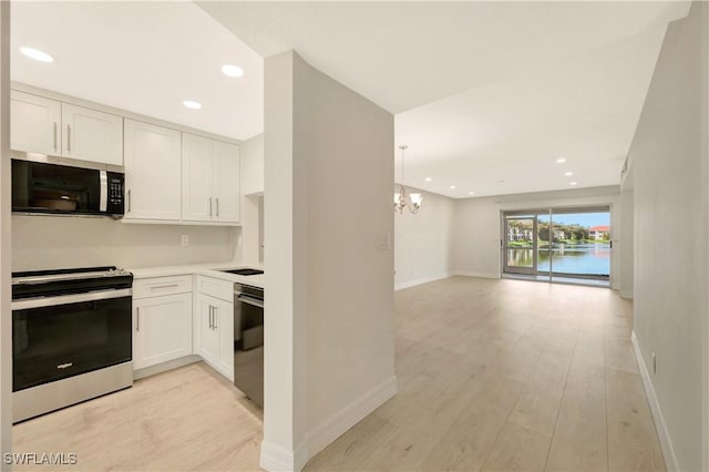 6448 Huntington Lakes Cir Unit 102, Naples, FL 34119 - kitchen featuring appliances with stainless steel finishes, a chandelier, light wood-style flooring, white cabinets, and recessed lighting