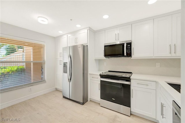 kitchen with stainless steel appliances, recessed lighting, light countertops, light wood-style floors, and white cabinets