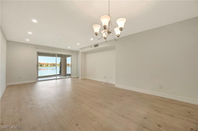 spare room featuring recessed lighting, a notable chandelier, visible vents, baseboards, and light wood-style floors