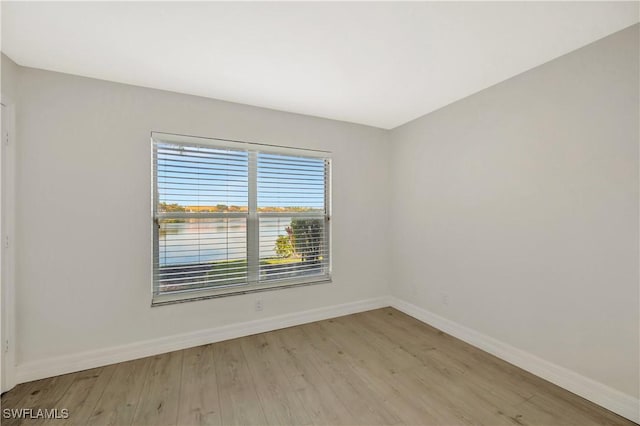 spare room with wood finished floors and baseboards