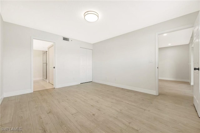 unfurnished room with light wood-style floors, baseboards, and visible vents