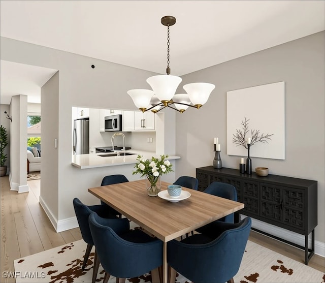 6448 Huntington Lakes Cir Unit 102, Naples, FL 34119 - dining area with light wood-type flooring and a chandelier