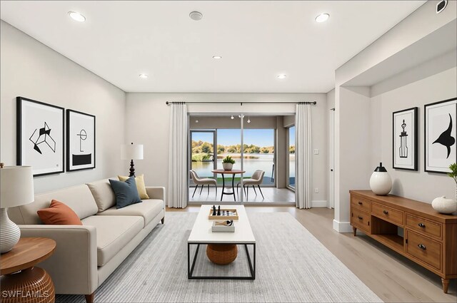6448 Huntington Lakes Cir Unit 102, Naples, FL 34119 - living room with light wood finished floors, recessed lighting, and a water view