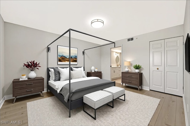 6448 Huntington Lakes Cir Unit 102, Naples, FL 34119 - bedroom featuring light wood-style floors and ensuite bath