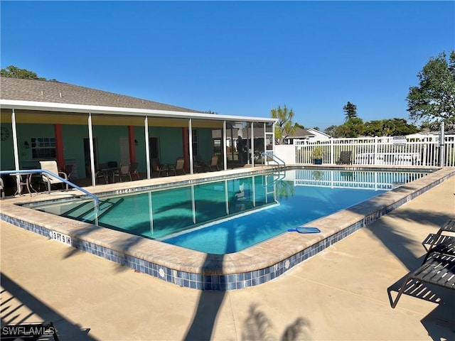 pool featuring a patio, fence, and a sunroom