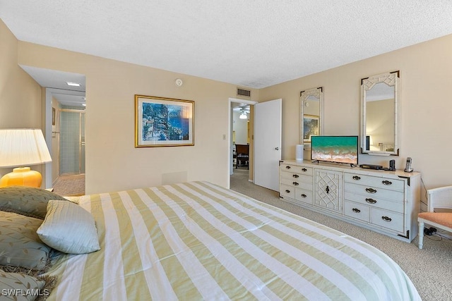 bedroom with light carpet, visible vents, and a textured ceiling