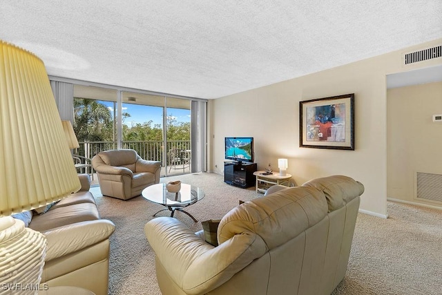 carpeted living area featuring visible vents, a textured ceiling, and expansive windows