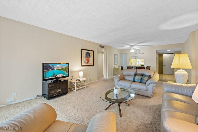 carpeted living room featuring visible vents, a textured ceiling, and ceiling fan