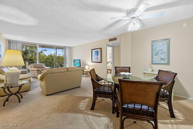 dining room featuring visible vents, baseboards, expansive windows, light carpet, and a textured ceiling