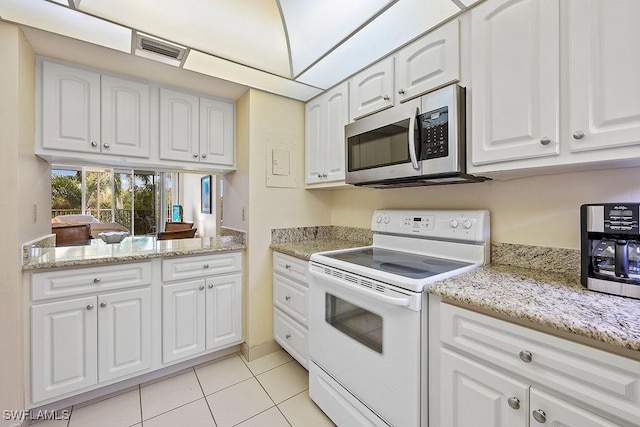 kitchen featuring light tile patterned floors, visible vents, white cabinetry, stainless steel microwave, and white range with electric stovetop