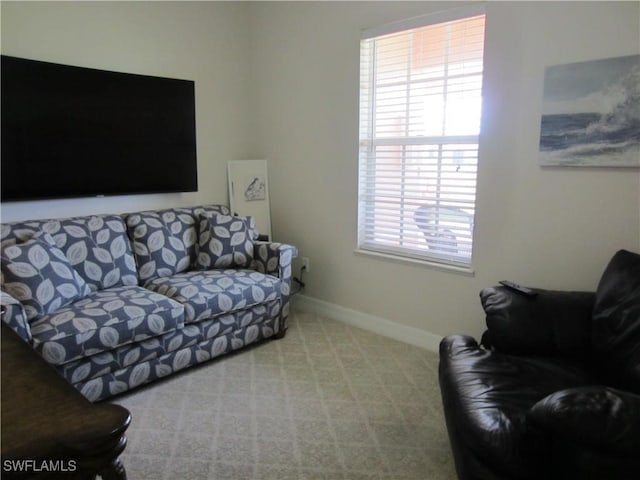 living area featuring carpet flooring and baseboards