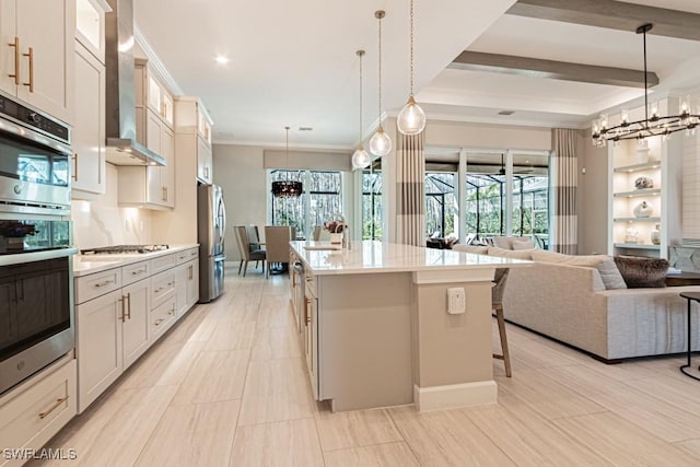 kitchen featuring open floor plan, stainless steel appliances, wall chimney exhaust hood, and light countertops