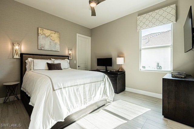 bedroom with ceiling fan, baseboards, and wood finished floors