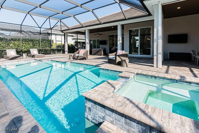 view of pool featuring glass enclosure, a pool with connected hot tub, a patio area, and outdoor lounge area