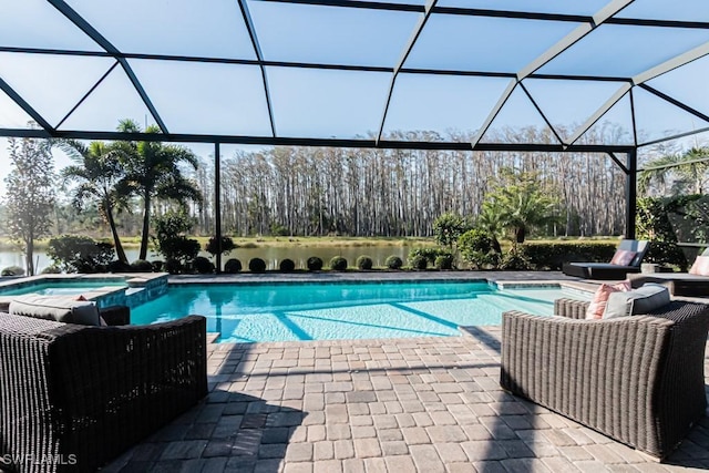 view of pool featuring a patio area, a pool with connected hot tub, and glass enclosure