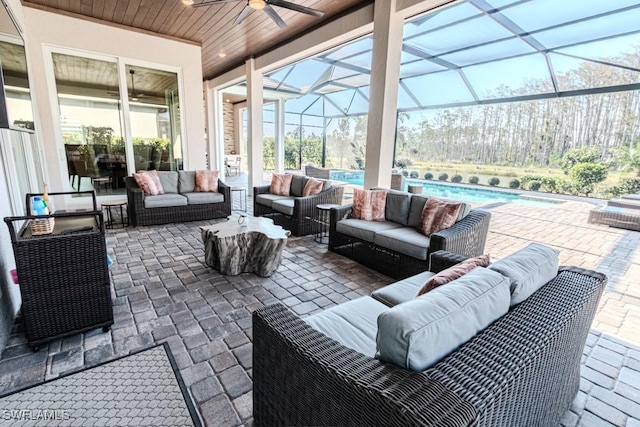 view of patio / terrace with an outdoor hangout area, glass enclosure, ceiling fan, and an outdoor pool