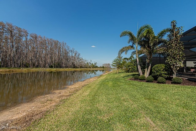 view of yard with a water view and a lanai