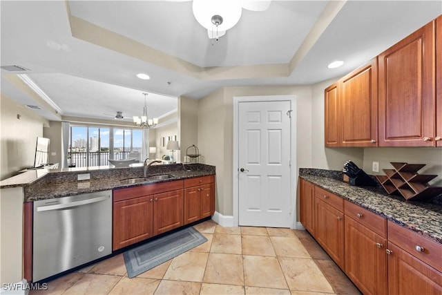 kitchen featuring dishwasher, a peninsula, a tray ceiling, a sink, and ceiling fan with notable chandelier