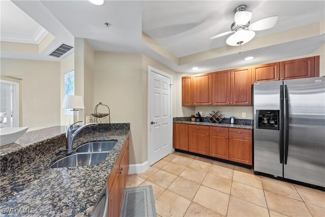 kitchen featuring visible vents, dark stone counters, a raised ceiling, stainless steel fridge with ice dispenser, and a sink