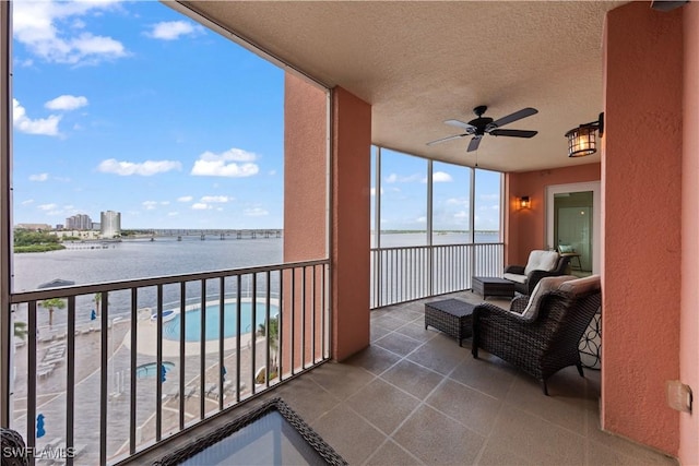 balcony with a water view and ceiling fan