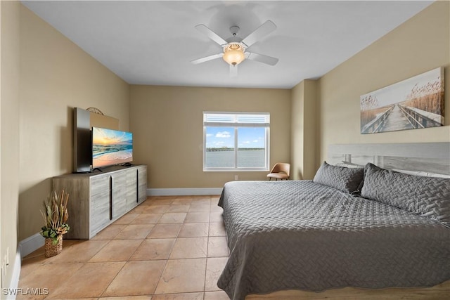 bedroom featuring a ceiling fan, light tile patterned flooring, and baseboards