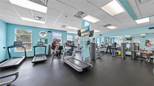 gym featuring a paneled ceiling, visible vents, and baseboards