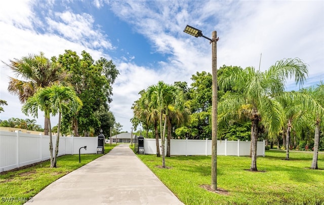 view of community with a yard and fence