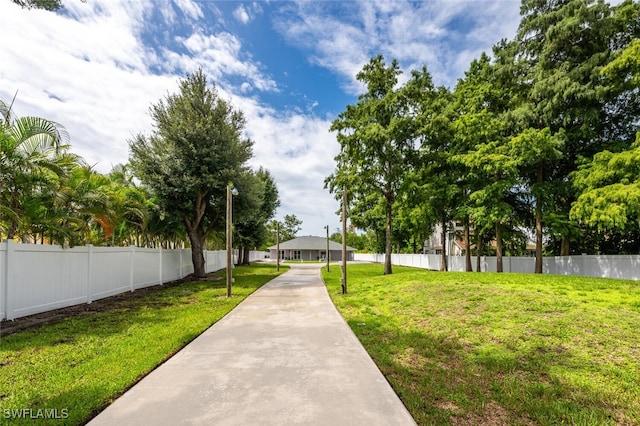 view of property's community featuring a yard and fence