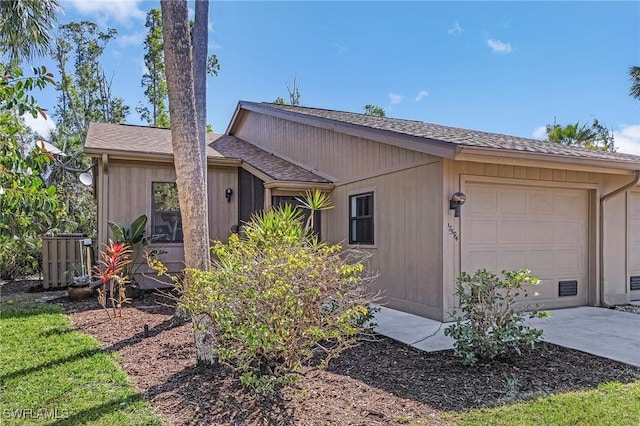 view of front of house with a garage, driveway, and roof with shingles