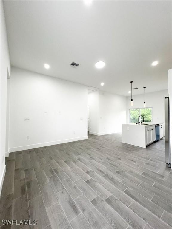 interior space featuring a sink, wood finished floors, visible vents, and recessed lighting