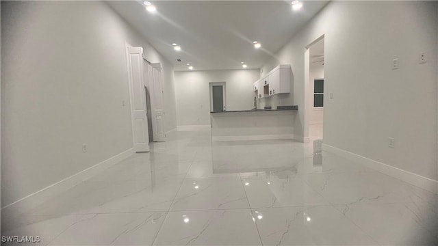 hallway with marble finish floor, recessed lighting, and baseboards