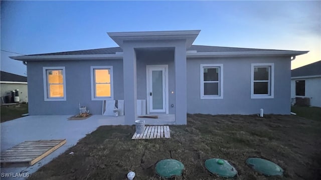 exterior space featuring a lawn, a patio area, and stucco siding