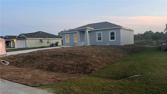 view of front of house featuring a lawn and stucco siding