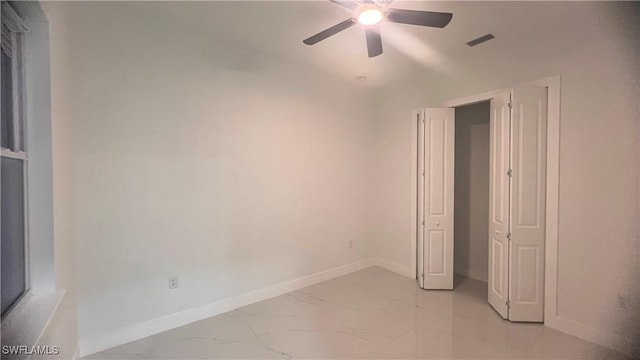 unfurnished bedroom with marble finish floor, visible vents, baseboards, and a ceiling fan