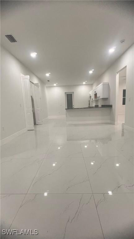 empty room featuring marble finish floor, visible vents, and baseboards