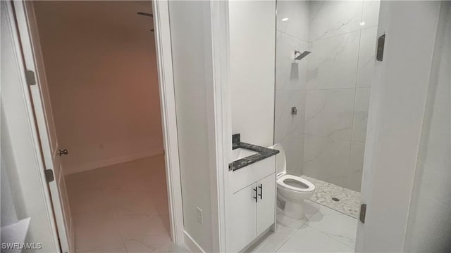 full bathroom featuring toilet, a stall shower, marble finish floor, and vanity