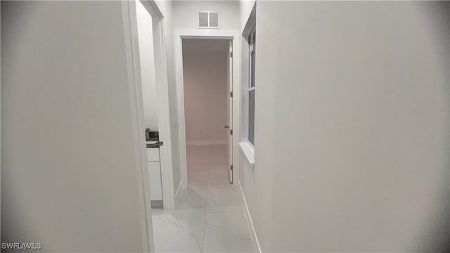 hall with marble finish floor, visible vents, and baseboards