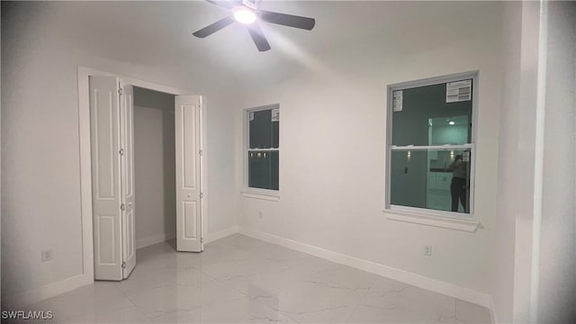 unfurnished bedroom with marble finish floor, baseboards, and a ceiling fan